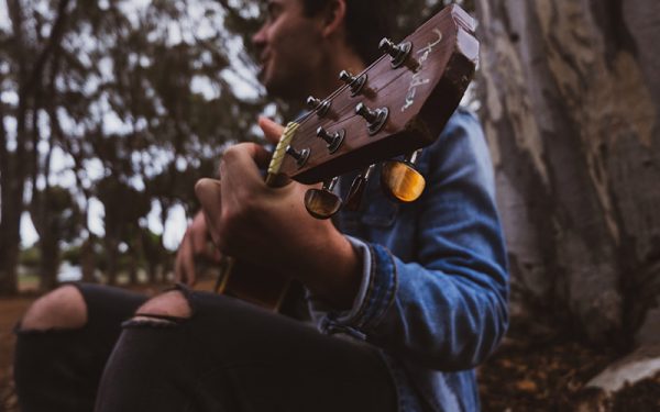 Person playing guitar in the woods